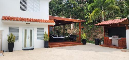 a gazebo with a hammock outside of a house at Palm's Luxury Suite with Private Jacuzzi in Aguada