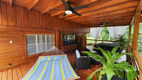 a hammock in a living room with a ceiling fan at Palm's Luxury Suite with Private Jacuzzi in Aguada