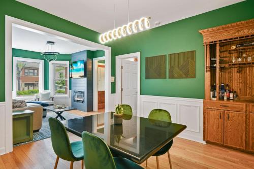 une salle à manger avec des murs verts, une table et des chaises dans l'établissement 2 Bed Apt w/ Office, Free Parking, Near Wrigley, à Chicago