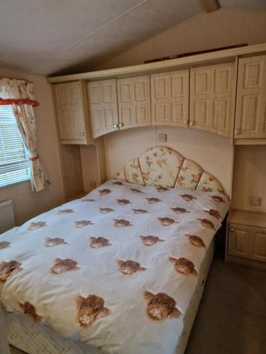 Un dormitorio con una cama con gatos. en Castlewigg holiday park Whithorn 2 bed caravan, en Newton Stewart