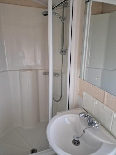 a bathroom with a sink and a shower at Castlewigg holiday park Whithorn 2 bed caravan in Newton Stewart