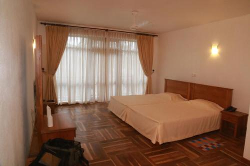 a bedroom with a bed and a large window at Alta Vista in Ella