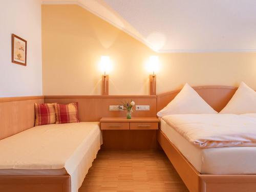 バート・ビルンバッハにあるFranzl's Ferienwohnungenのベッド2台 壁にランプ2つが備わる客室です。