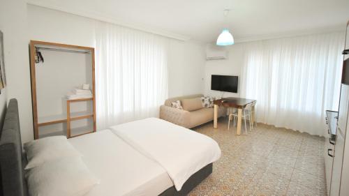 Habitación de hotel con cama y sofá en Anatolian Homes & Apart, en Antalya