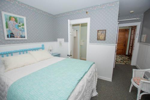 a bedroom with a bed in a room with blue wallpaper at Terrace Inn and 1911 Restaurant in Petoskey