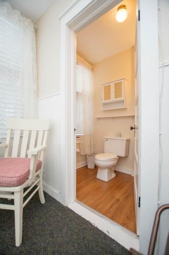 a bathroom with a toilet and a chair at Terrace Inn and 1911 Restaurant in Petoskey