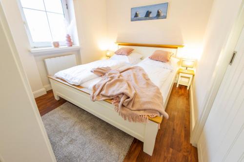 a bedroom with a bed with a blanket on it at Villa Marina - Weitblick aufs Meer in Wangerooge