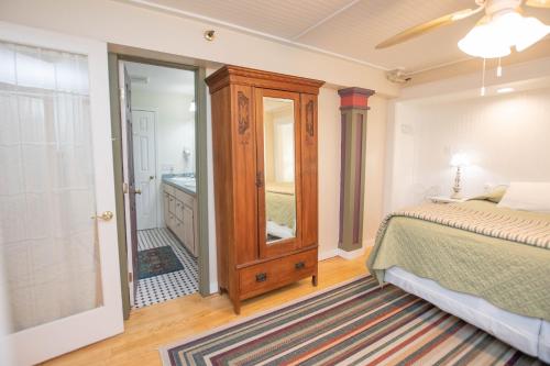 a bedroom with a bed and a bathroom with a mirror at Terrace Inn and 1911 Restaurant in Petoskey