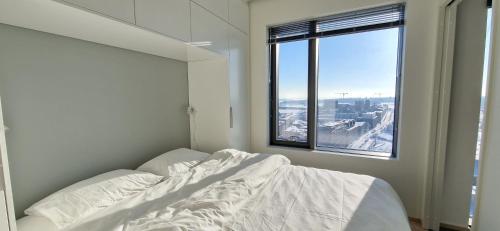 a white bedroom with a bed and a window at Sea & City view Home near Nature in Helsinki