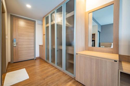a hallway with glass doors and a mirror at Rain Tree Condominium in Chiang Mai