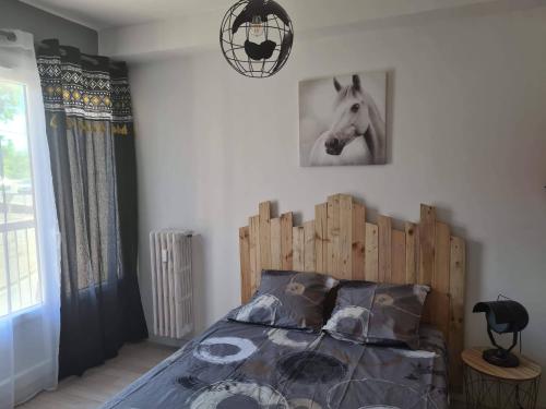 Un dormitorio con una cama de madera con una foto de caballo en la pared en Mireio Arles centre climatisé 1 à 6 personnes Appartement, en Arles