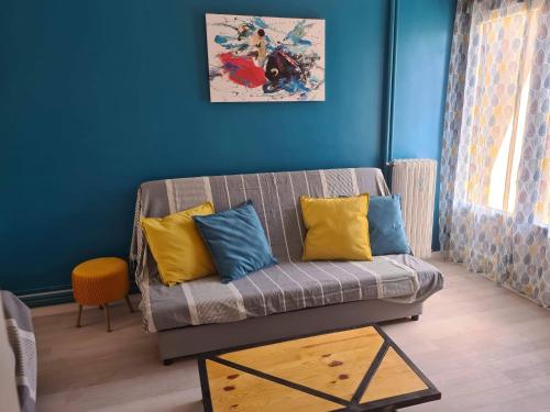 sala de estar con sofá y paredes amarillas y azules en Mireio Arles centre climatisé 1 à 6 personnes Appartement, en Arles