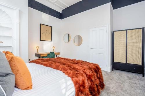 ein Schlafzimmer mit einem Bett mit einer orangefarbenen Decke darauf in der Unterkunft Coppergate Mews Grimsby No.2 - 2 bed, 2 bath, ground floor apartment in Grimsby