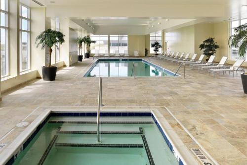a swimming pool in a building with chairs and tables at Marriott Raleigh City Center in Raleigh