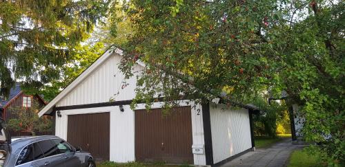un garage blanc et marron avec une voiture garée à côté de celui-ci dans l'établissement Ekonomirum i Karlstad, à Karlstad