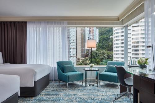 香港にあるJW マリオット ホテル 香港のベッドと椅子、大きな窓が備わるホテルルームです。