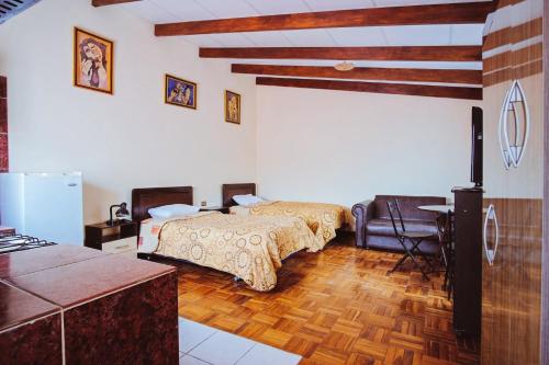 sypialnia z 2 łóżkami i stołem oraz kuchnia w obiekcie La Maison Martinet w mieście Uyuni