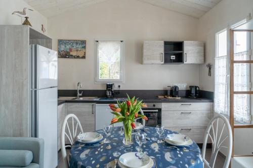 une cuisine avec une table avec un vase de fleurs dessus dans l'établissement À moins de 500m de la plage, 2 adultes - 3 enfants, à LʼÉpine
