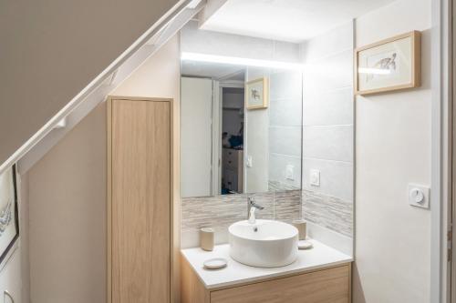 a bathroom with a sink and a mirror at À moins de 500m de la plage, 2 adultes - 3 enfants in LʼÉpine