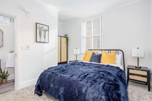 a bedroom with a bed with blue comforter and yellow pillows at Coppergate Mews Grimsby No.3 - 2 bed, 2 bath, ground floor apartment in Grimsby