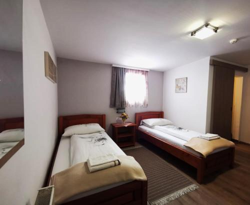 a room with two beds and a window at Pensiunea Evelyn in Gîrleni