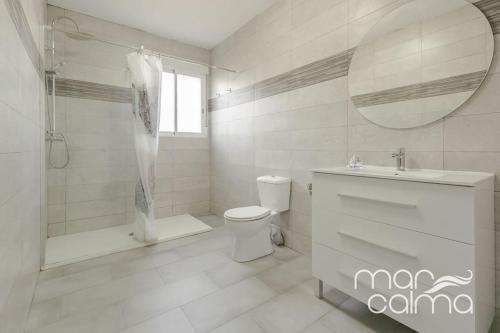a bathroom with a toilet and a shower and a sink at Villa Elvira by MarCalma in Les tres Cales