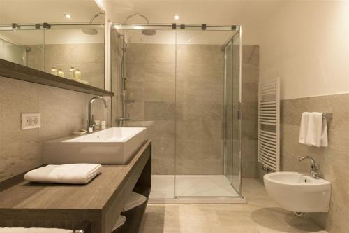 a bathroom with a shower and a sink and a toilet at Passo Sella Dolomiti Mountain Resort in Selva di Val Gardena