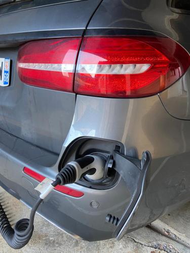 a car with a charging cord plugged into the trunk at Hotel Colmar Vignes Eguisheim in Eguisheim