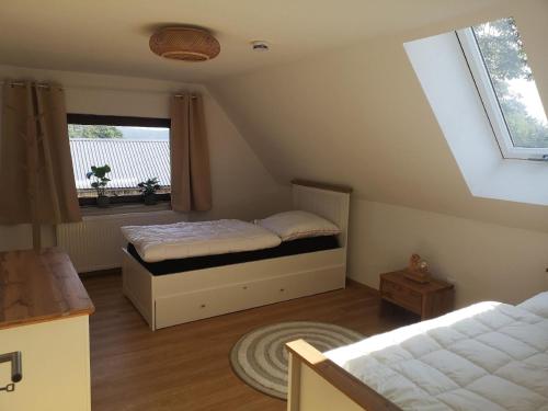 um quarto no sótão com uma cama e uma janela em Große Ferienwohnung in Neuhaus ADEger mit Whirlpool, Grill und Garten em Hohenberg an der Eger