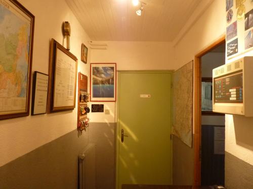 un pasillo con una puerta verde en una habitación en Hotel Régina, en Salon-de-Provence