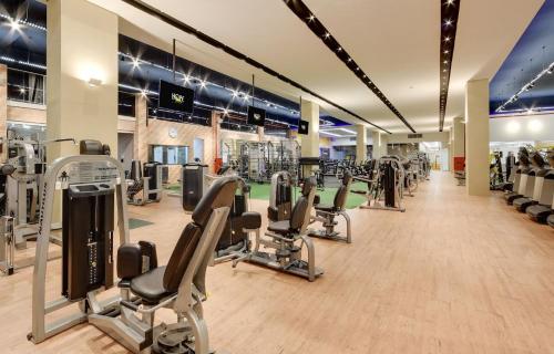 un gimnasio con filas de cintas de correr y máquinas de cardio en House Inn Hotel - Anashopping en Anápolis