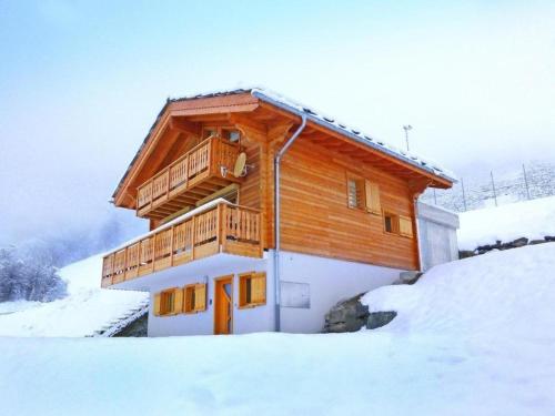 a wooden house with a balcony in the snow at Chalet Falcons Nest in Hérémence