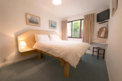 a bedroom with a bed and a television in it at Beck Yeat Cottage Coniston in Coniston