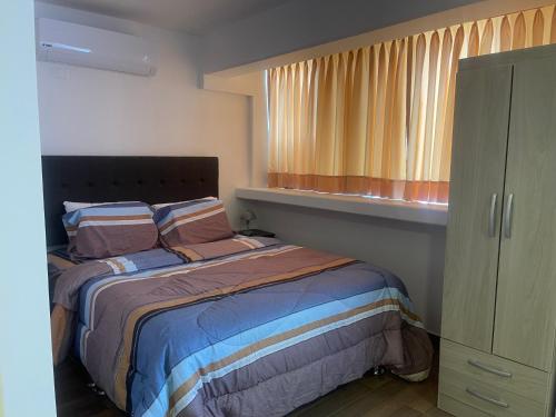 a small bedroom with a bed and a window at (21) Depto. nuevo y acogedor en Miraflores in Lima