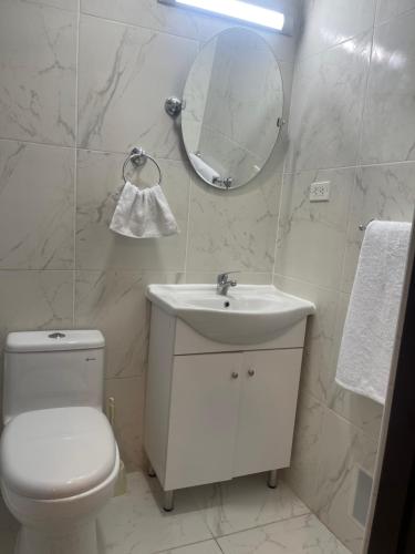 a bathroom with a toilet and a sink and a mirror at (21) Depto. nuevo y acogedor en Miraflores in Lima