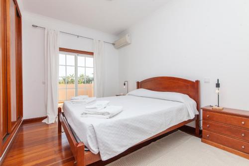 ラゴスにあるAnastasia Apartment in Lagosのベッドと窓のある白い寝室