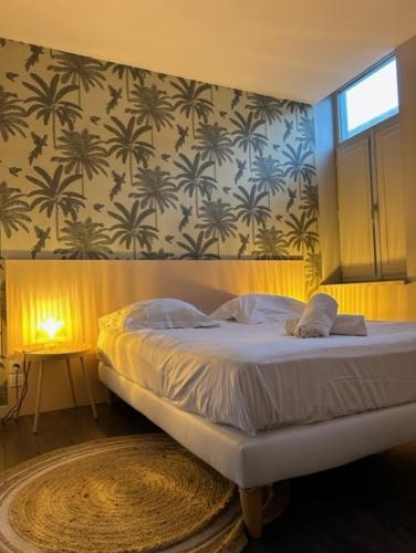 - une chambre avec un lit et un mur orné de palmiers dans l'établissement Superbe appartement - Coeur du Vieux-Lille, à Lille