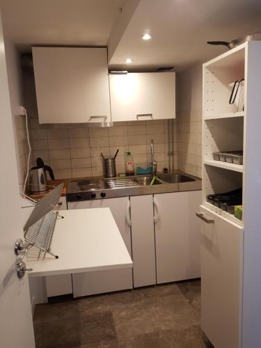 una pequeña cocina con armarios blancos y fregadero en Ekonomirum i Karlstad, en Karlstad