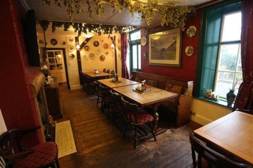 a dining room with tables and chairs in a restaurant at Strands Hotel/Screes Inn & Micro Brewery in Nether Wasdale