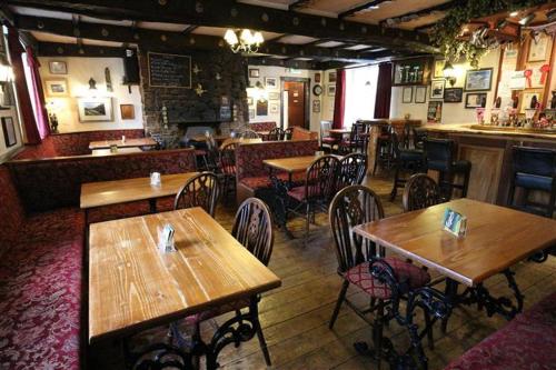a restaurant with wooden tables and chairs and a bar at Strands Hotel/Screes Inn & Micro Brewery in Nether Wasdale