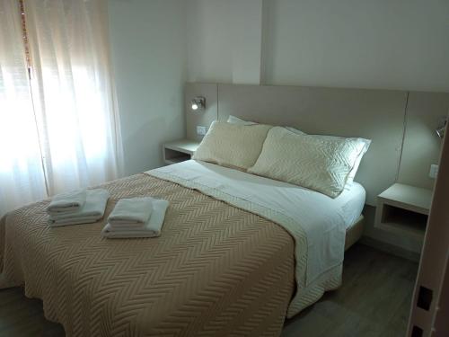 1 dormitorio con 1 cama con 2 toallas en Apart 9 De Julio en Río Cuarto