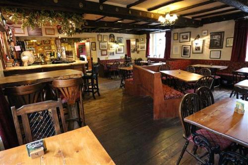 a restaurant with tables and chairs and a bar at Strands Hotel/Screes Inn & Micro Brewery in Nether Wasdale