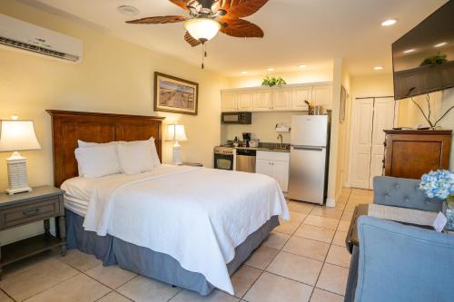 a bedroom with a large bed and a kitchen at The Capri at Siesta in Siesta Key