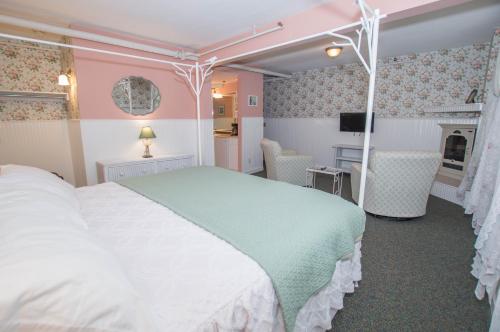 a bedroom with a white bed and a desk at Terrace Inn and 1911 Restaurant in Petoskey