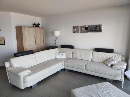 a living room with a white couch and chairs at LUXURY APP, frontal sea View + south terrace + garage in Middelkerke