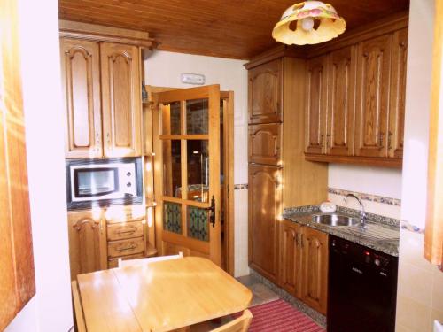 Magros的住宿－Casa da Laxa，厨房配有木制橱柜和木桌。