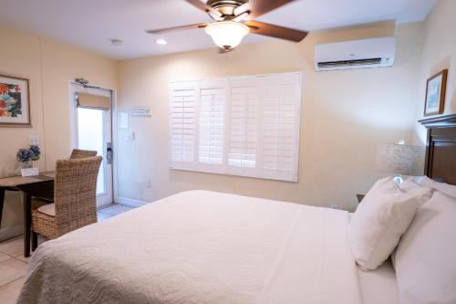 a bedroom with a bed and a ceiling fan at The Capri at Siesta in Siesta Key