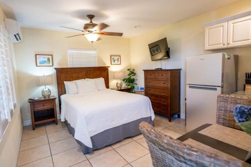 um quarto com uma cama branca e um frigorífico em The Capri at Siesta em Siesta Key