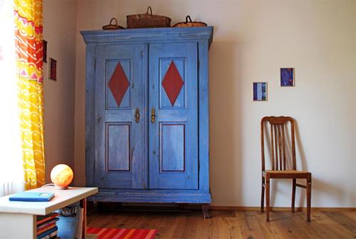 un armario azul en una habitación con una mesa y una silla en Grüne Auszeit, en Georgensgmünd