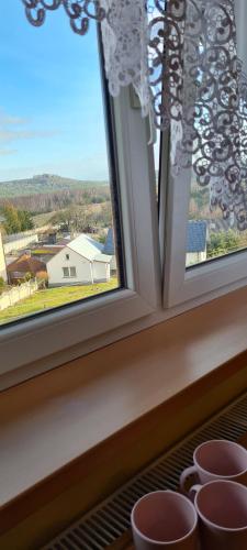 a window with three cups sitting on a ledge at Skalny Widok in Hucisko